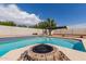 Backyard pool features a fire pit and lush landscaping, creating a serene oasis for relaxation and entertaining at 10358 N 78Th Ave, Peoria, AZ 85345