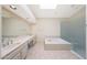 Bright bathroom featuring double sinks, a soaking tub, and a separate glass-enclosed shower at 10613 E Nacoma Dr, Sun Lakes, AZ 85248
