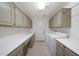 Bright laundry room features neutral cabinets, white laminate countertops, and modern washer and dryer at 10613 E Nacoma Dr, Sun Lakes, AZ 85248