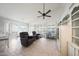 Open living room with vaulted ceiling, tile floors, plantation shutters, ceiling fan, and built-in cabinets at 10613 E Nacoma Dr, Sun Lakes, AZ 85248