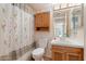 Functional bathroom equipped with essential fixtures, single sink vanity, and tiled shower with curtain at 10619 N 38Th Ave, Phoenix, AZ 85029