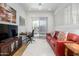 Inviting living room features a comfortable red sofa, desk, TV, and light-filled windows at 11000 N 77Th Pl # 2042, Scottsdale, AZ 85260