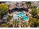 Aerial view of a community pool with a sun deck, lush landscaping and a covered veranda at 11000 N 77Th Pl # 2042, Scottsdale, AZ 85260