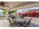 Charming backyard with a covered patio, desert landscaping, and vibrant bougainvillea at 1216 E Rowlands Ln, Phoenix, AZ 85022