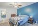 Comfortable bedroom featuring a ceiling fan, blue accent wall, and stylish bedspread at 1216 E Rowlands Ln, Phoenix, AZ 85022
