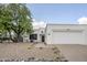 Charming single-story home with desert landscaping, a large tree, and a two-car garage at 1216 E Rowlands Ln, Phoenix, AZ 85022