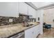 Modern kitchen with granite countertops, mosaic backsplash, stainless steel appliances, and white cabinetry at 1216 E Rowlands Ln, Phoenix, AZ 85022