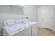 Bright laundry room with a white washer and dryer and a tile floor at 1216 E Rowlands Ln, Phoenix, AZ 85022