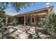 Spacious backyard featuring a covered patio, decorative lighting, and flagstone pavers, surrounded by mature trees at 1243 W Sherri Dr, Gilbert, AZ 85233