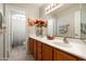 Bathroom featuring double sinks, a large mirror, and neutral decor, with a view into the shower and toilet area at 1243 W Sherri Dr, Gilbert, AZ 85233