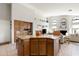 Open concept kitchen features granite counters, central island, wood cabinets and seamless flow into the adjacent living room at 1243 W Sherri Dr, Gilbert, AZ 85233