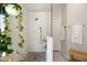Modern bathroom includes glass-enclosed shower, pebble floor, grab bar, bench and unique hanging vines at 1243 W Sherri Dr, Gilbert, AZ 85233