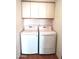 Convenient laundry room featuring a modern washer and dryer set and storage cabinets, offering functional space at 127 S 75Th Pl, Mesa, AZ 85208