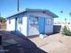 Small outbuilding with secure windows and light blue trim nestled in a gravel lot under a clear blue sky at 127 S 75Th Pl, Mesa, AZ 85208