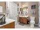 Well-lit bathroom featuring dual vanities, a toilet, and nautical decorations at 12798 W Dove Wing Way, Peoria, AZ 85383