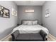 Well-lit bedroom features a gray upholstered bed with decorative pillows and a gray bench at 12798 W Dove Wing Way, Peoria, AZ 85383