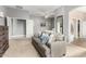 Comfortable bedroom features a gray sofa with pillows, doors to other rooms and a full-length mirror at 12798 W Dove Wing Way, Peoria, AZ 85383
