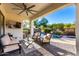Covered patio with comfortable seating, ceiling fan, and views of the backyard pool at 12798 W Dove Wing Way, Peoria, AZ 85383