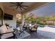 Comfortable covered patio with stylish seating overlooking a serene pool and lush backyard at 12798 W Dove Wing Way, Peoria, AZ 85383
