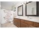 Bathroom featuring double sinks with wood cabinets and decorative mirrors at 12936 W Flower St, Avondale, AZ 85392