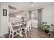 Cozy dining area with white wood table and chairs, natural lighting, and wood laminate flooring at 12936 W Flower St, Avondale, AZ 85392
