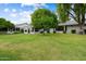 Large backyard area with mature trees, patio, and lots of grass at 13023 W Tangelo Dr, Sun City West, AZ 85375