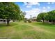 Lush backyard with mature trees and expansive grassy area at 13023 W Tangelo Dr, Sun City West, AZ 85375