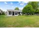 Expansive backyard featuring a covered patio, lush lawn, and fruit trees at 13023 W Tangelo Dr, Sun City West, AZ 85375