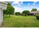 Picturesque backyard with lush green lawn and mature shade trees at 13023 W Tangelo Dr, Sun City West, AZ 85375