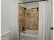 Bathroom featuring white tub with tiled wall surround, shower niche, and modern fixtures at 13023 W Tangelo Dr, Sun City West, AZ 85375