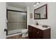 Well-lit bathroom with vanity, granite countertop, dark wood cabinets, and tiled shower with glass door at 13023 W Tangelo Dr, Sun City West, AZ 85375