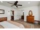 Bedroom showcasing tile floors, ceiling fan, walk-in closet, and connecting bathroom, and a warm color palette at 13023 W Tangelo Dr, Sun City West, AZ 85375