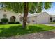Beautiful single-story home with a two-car garage, a lush lawn, and mature trees providing ample shade at 13023 W Tangelo Dr, Sun City West, AZ 85375