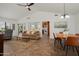 Open-concept living room with high ceilings, tile floors, comfortable seating, and ample natural light at 13023 W Tangelo Dr, Sun City West, AZ 85375