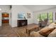 Inviting living room with plush sofa, recliner, fireplace, and large window providing natural light and views at 13023 W Tangelo Dr, Sun City West, AZ 85375