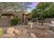 Inviting front entrance with custom iron door, lush landscaping, and elegant lighting fixtures at 15135 E Sundown Dr, Fountain Hills, AZ 85268
