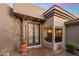 Close up view of home's entry with custom doors and desert landscaping at 15135 E Sundown Dr, Fountain Hills, AZ 85268
