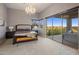 Spacious primary bedroom with decorative chandelier, terrace access, and mountain views at 15135 E Sundown Dr, Fountain Hills, AZ 85268