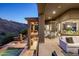 Expansive covered patio with dining area, seating, and views of the pool and mountains beyond at 15135 E Sundown Dr, Fountain Hills, AZ 85268