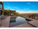 Infinity pool with a shaded lounge area provides a tranquil space with scenic mountain views at 15135 E Sundown Dr, Fountain Hills, AZ 85268