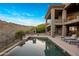 Expansive pool area features a hot tub, fireplace, and outdoor kitchen, perfect for entertaining with mountain views at 15135 E Sundown Dr, Fountain Hills, AZ 85268