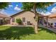 Well-maintained backyard with green turf, brick-paver borders, and a covered patio perfect for relaxing at 15633 W Acapulco Ln, Surprise, AZ 85379