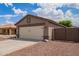 Single Gathering home featuring an attached garage with a two car driveway and low maintenance desert landscaping at 15633 W Acapulco Ln, Surprise, AZ 85379