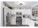 Well-lit kitchen with white cabinets, stainless steel appliances, and elegant backsplash, offering a modern culinary experience at 15633 W Acapulco Ln, Surprise, AZ 85379