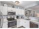 Bright kitchen with white cabinetry, stainless steel appliances, and stylish backsplash, creating an inviting cooking space at 15633 W Acapulco Ln, Surprise, AZ 85379