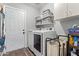 Functional laundry room with modern machines, shelving for storage, and convenient access at 15633 W Acapulco Ln, Surprise, AZ 85379