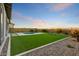 Expansive backyard features lush artificial turf, a refreshing pool, and a relaxing hammock area at 16566 W Saguaro Park Ln, Surprise, AZ 85387