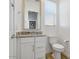 Well-lit bathroom featuring granite countertop, sink, and toilet at 16566 W Saguaro Park Ln, Surprise, AZ 85387