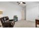 Comfortable bedroom retreat with a leather reclining chair and natural lighting at 16566 W Saguaro Park Ln, Surprise, AZ 85387