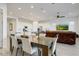 Bright dining room with seating for six featuring gray wood floors and modern furnishings at 16566 W Saguaro Park Ln, Surprise, AZ 85387